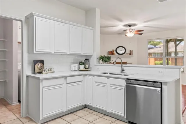 a kitchen with a sink stainless steel appliances and white cabinets
