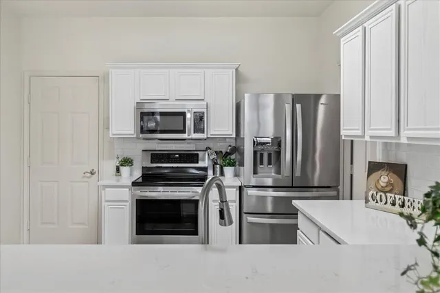 a kitchen with white cabinets and a sink