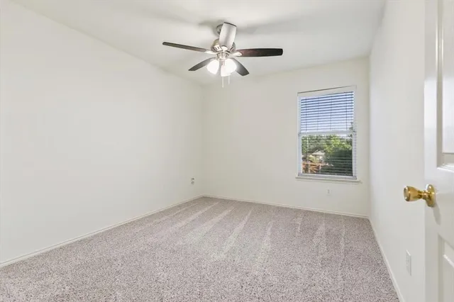a view of a room with a ceiling fan and a window