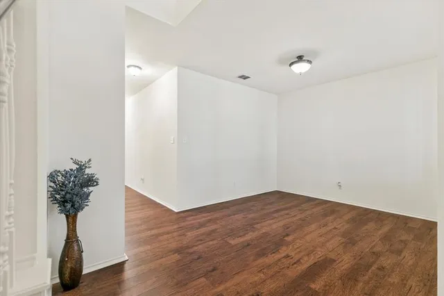 a view of an empty room with window and chandelier fan