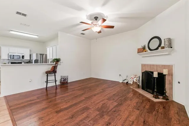 a view of an empty room with a fireplace and a window