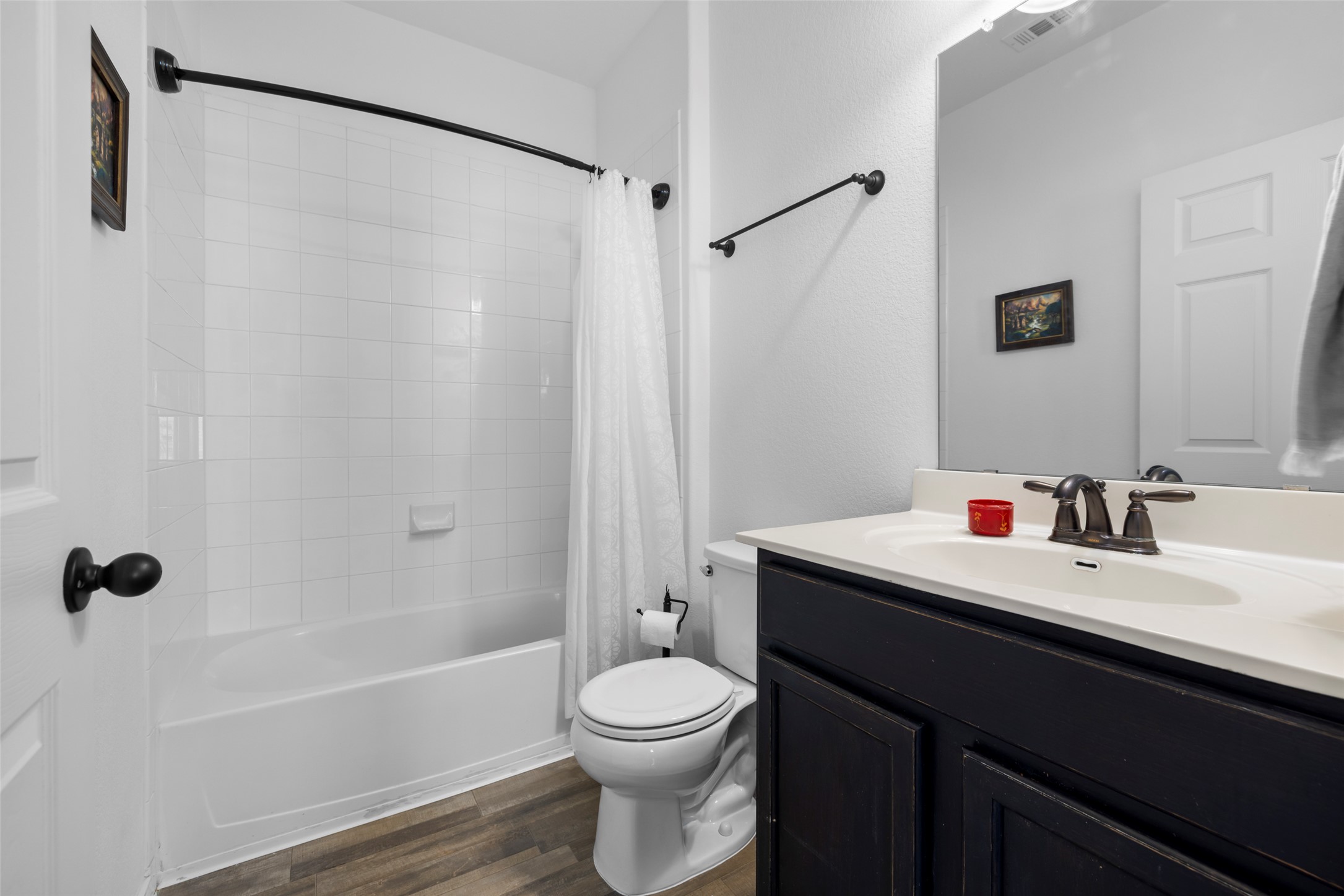 13113 Titanium Street Austin, TX 78754 - Photo 12 of 39 Full bath featuring vanity, wood-look vinyl floors, and a tiled shower / bath combo