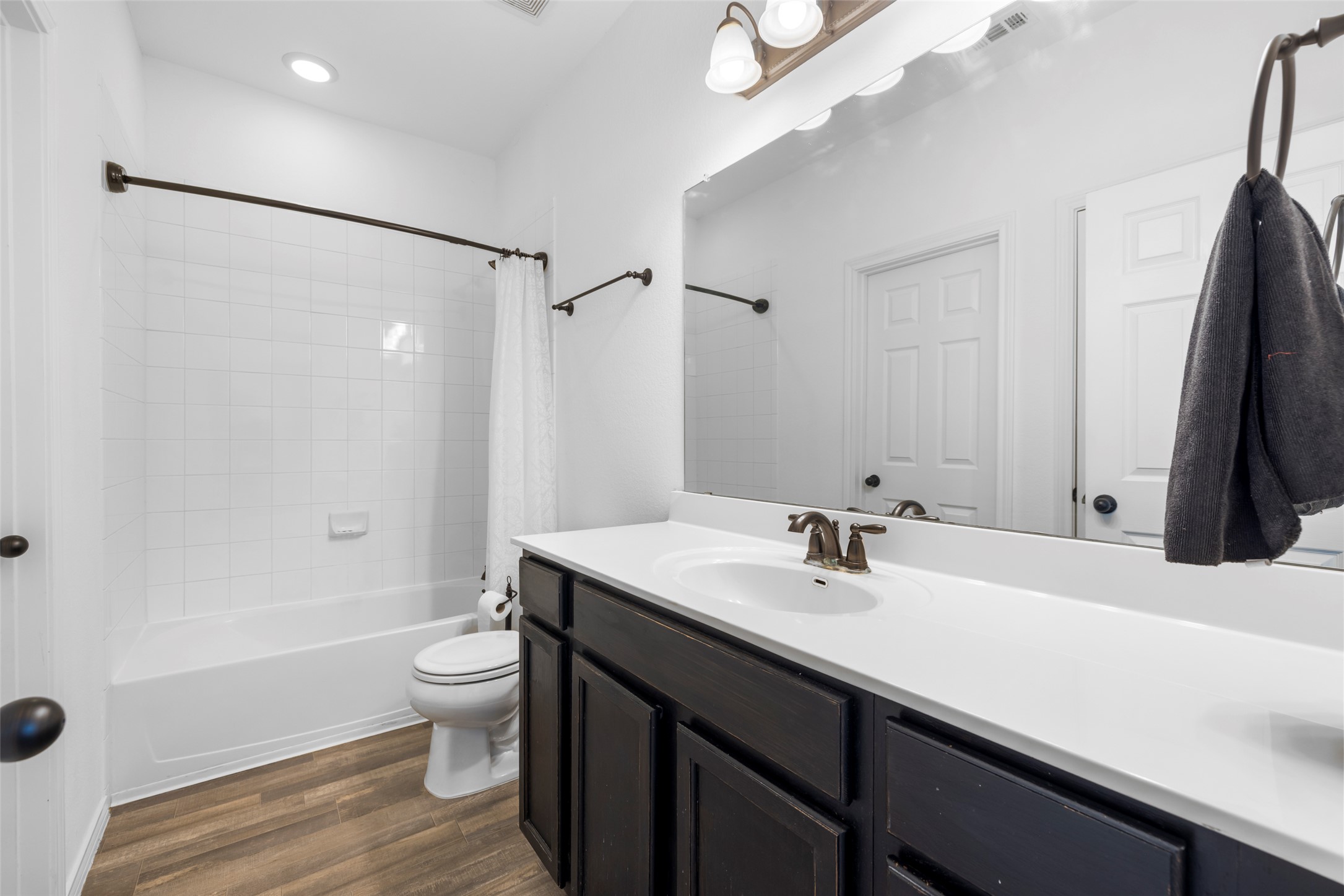 13113 Titanium Street Austin, TX 78754 - Photo 18 of 39 Full bathroom with wood-look vinyl floors, vanity, and tiled shower / bath combo