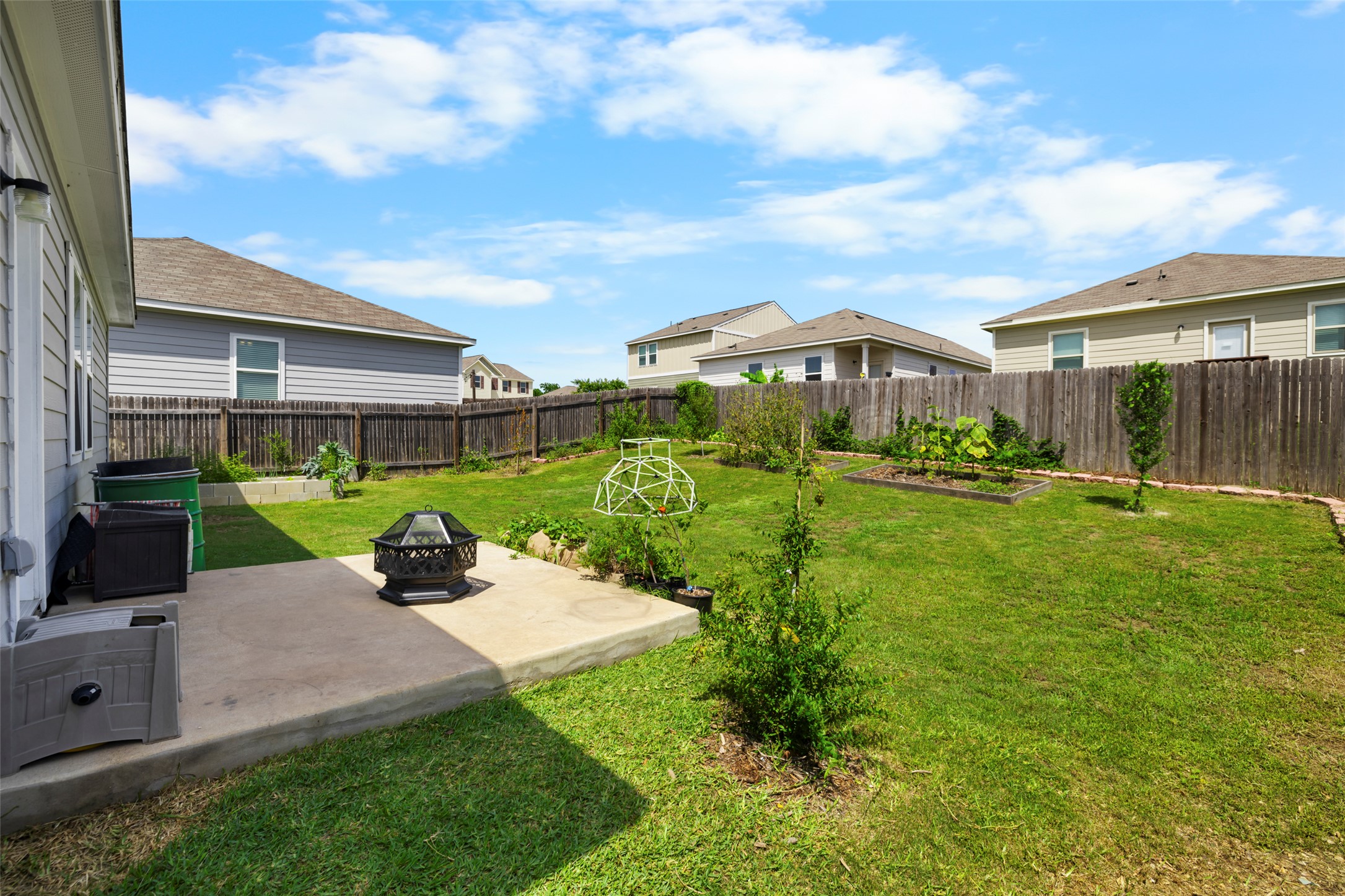 13113 Titanium Street Austin, TX 78754 - Photo 21 of 39 Spacious fenced backyard with an outdoor fire pit, a patio, and a garden