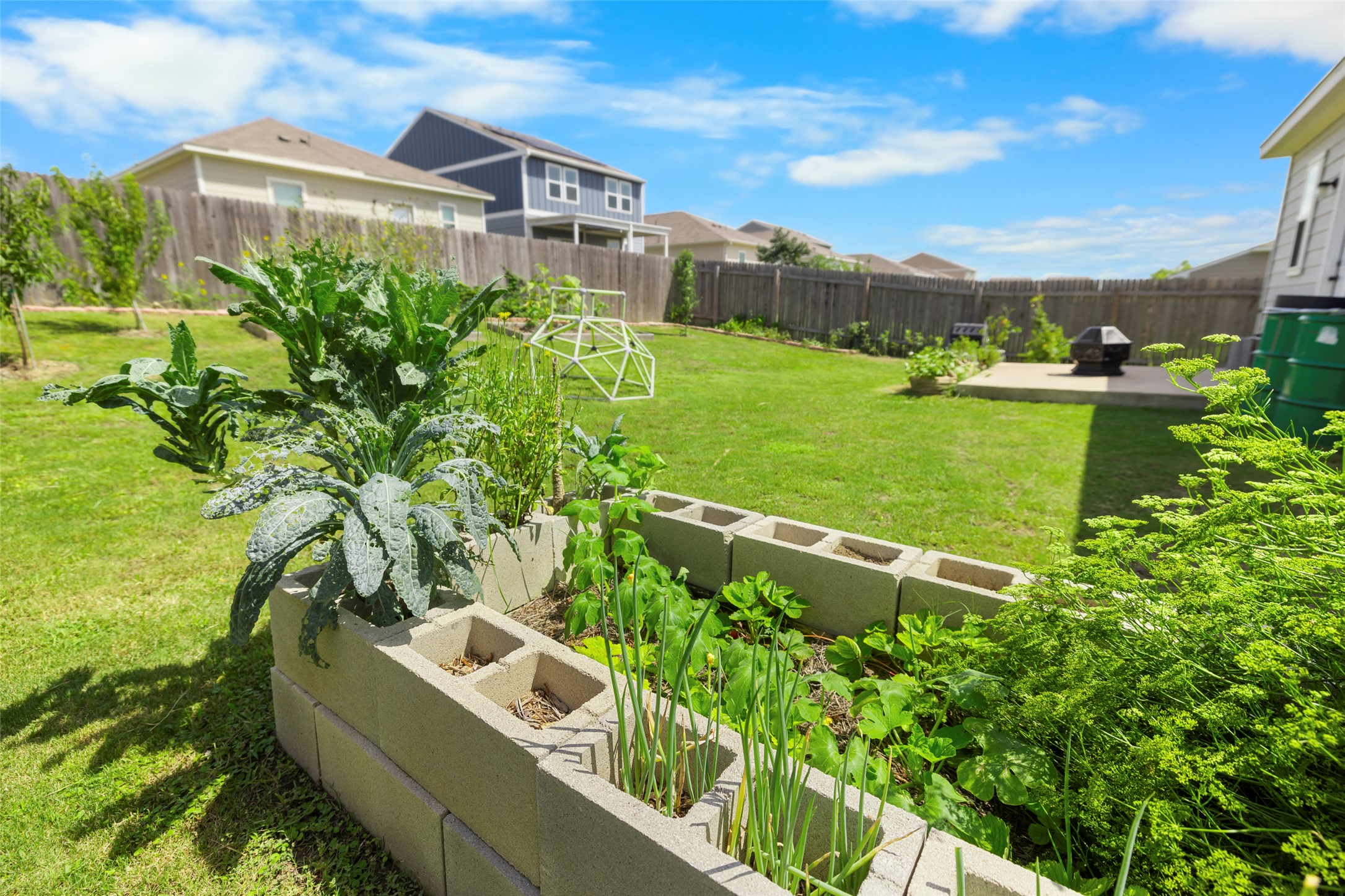 13113 Titanium Street Austin, TX 78754 - Photo 28 of 39 Fenced backyard featuring an outdoor fire pit, a garden, and a patio