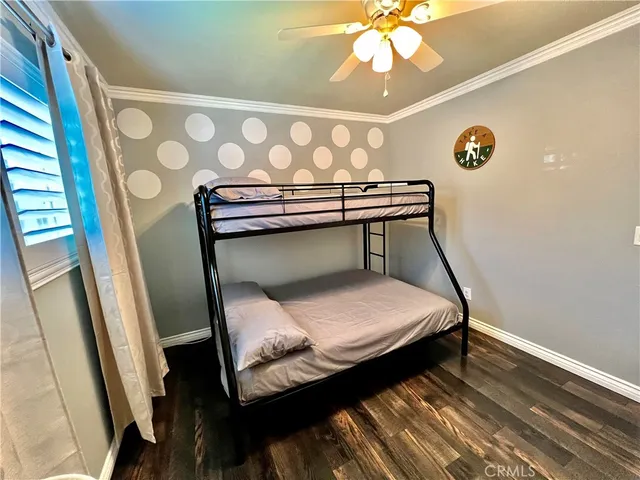 a bedroom with a bed and a flat tv screen on dresser