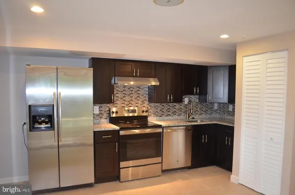 a kitchen with stainless steel appliances granite countertop a stove and a refrigerator