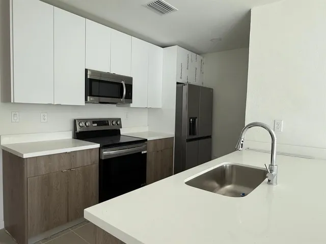 a kitchen with a sink a stove and refrigerator