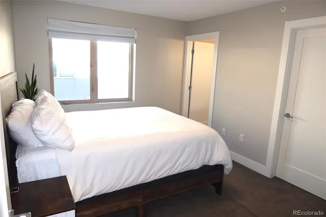 a large bed sitting in a bedroom next to a window