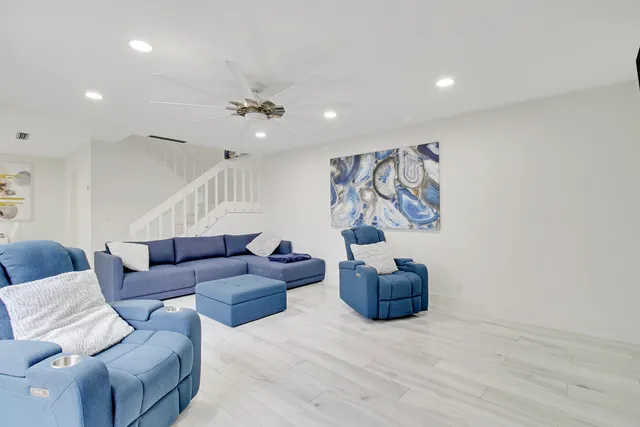 a living room with furniture and a ceiling fan
