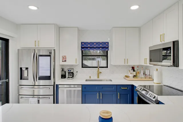 a kitchen with stainless steel appliances granite countertop a refrigerator stove and sink