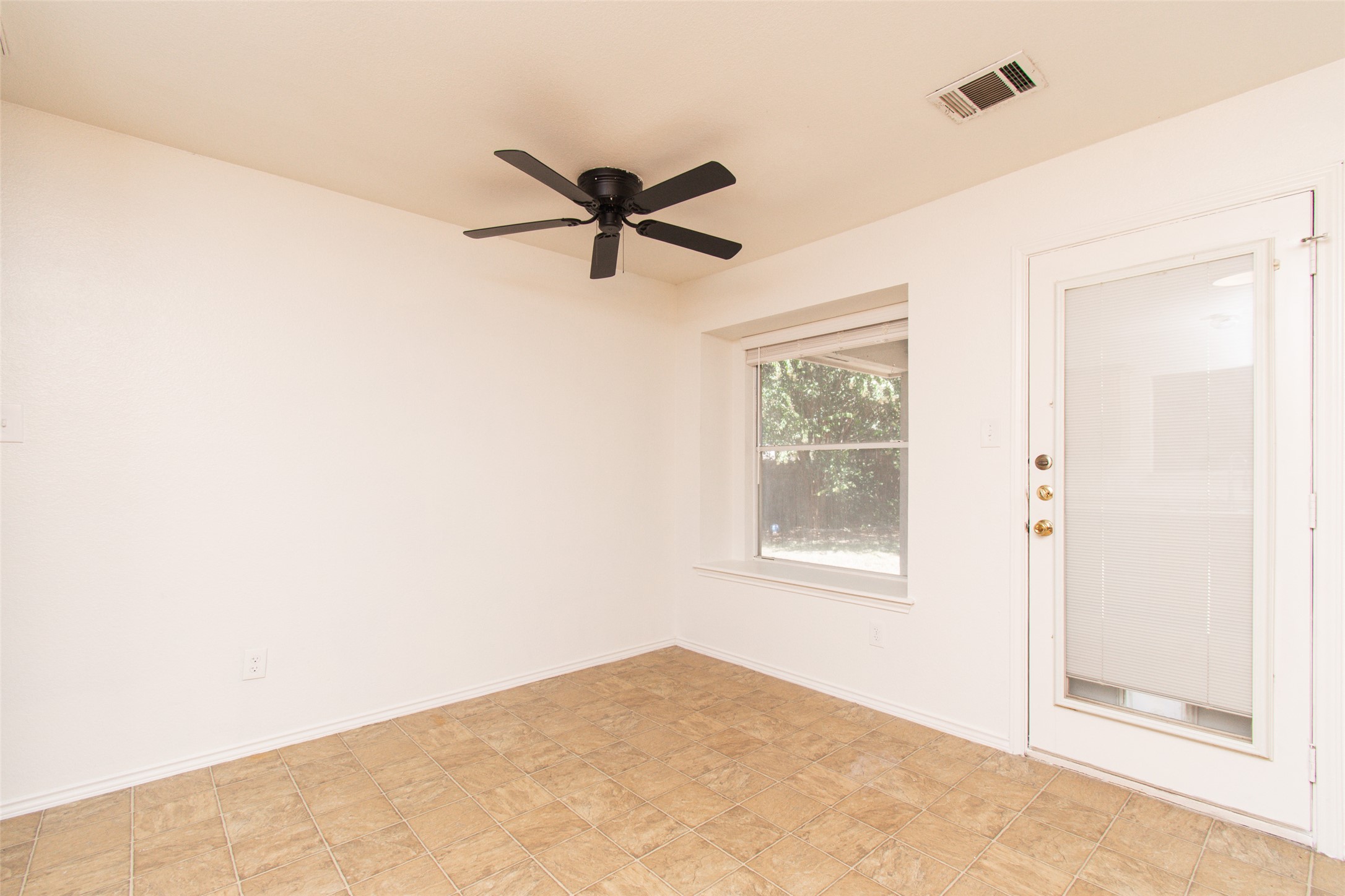 1436 Roxanne's Run Pflugerville, TX 78660 - Photo 6 of 24 Tiled flooring and natural light from a glass-paneled door anchor this versatile casual dining space.