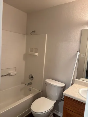 a white toilet and tub next to a bathroom sink