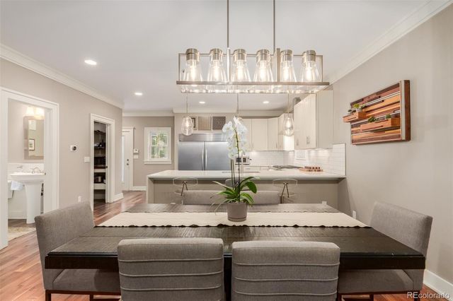 a kitchen with a refrigerator and stools