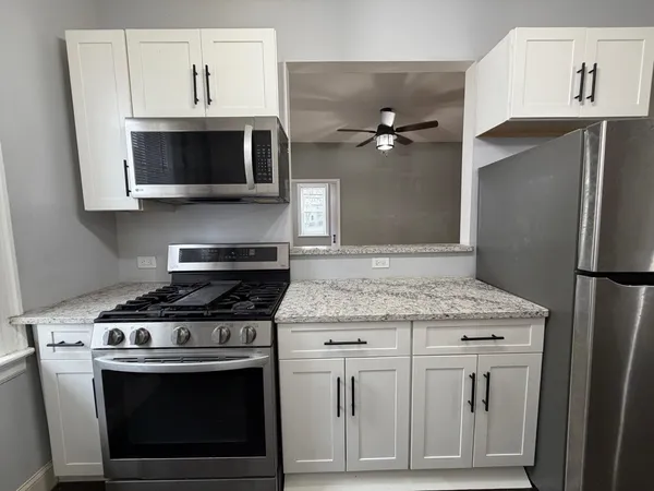 a kitchen with appliances a sink and cabinets