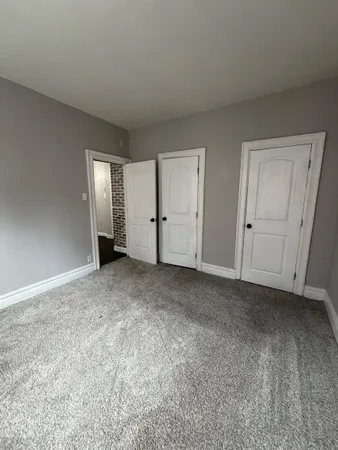 a view of an empty room with closet and entryway