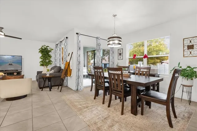 a view of a dining room and livingroom with furniture wooden floor a chandelier