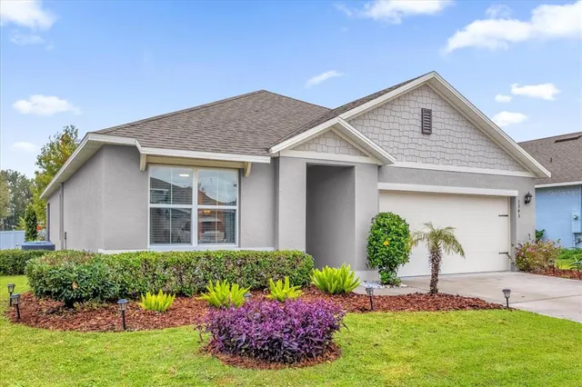 a front view of a house with a yard and potted plants