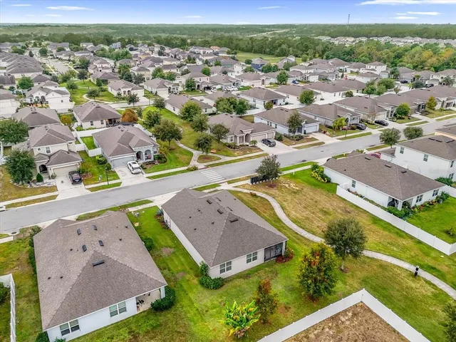 an aerial view of residential houses with outdoor space and parking