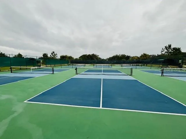 an outdoor space with green field and trees