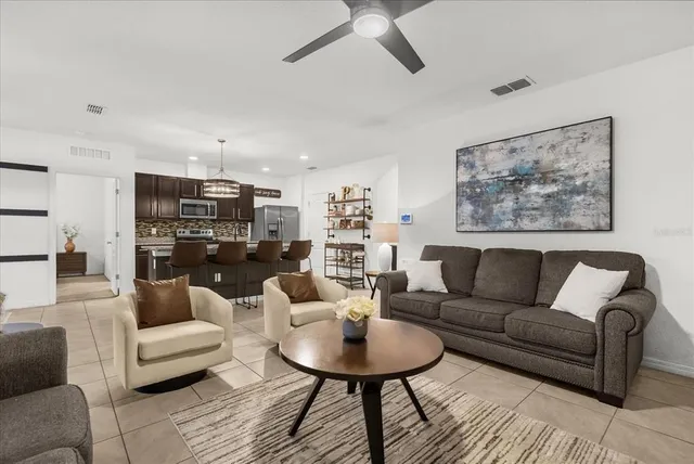 a living room with furniture and a view of kitchen