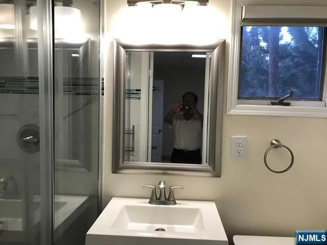 a bathroom with a sink a mirror and shower