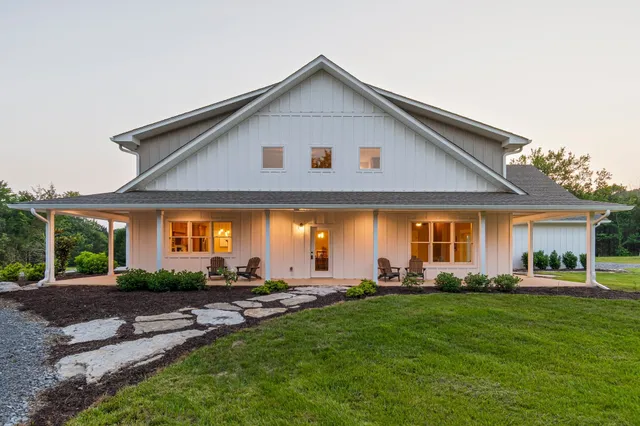 a kitchen with stainless steel appliances granite countertop a sink a stove a refrigerator and island with wooden floor