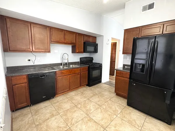 a kitchen with stainless steel appliances granite countertop a refrigerator stove and sink