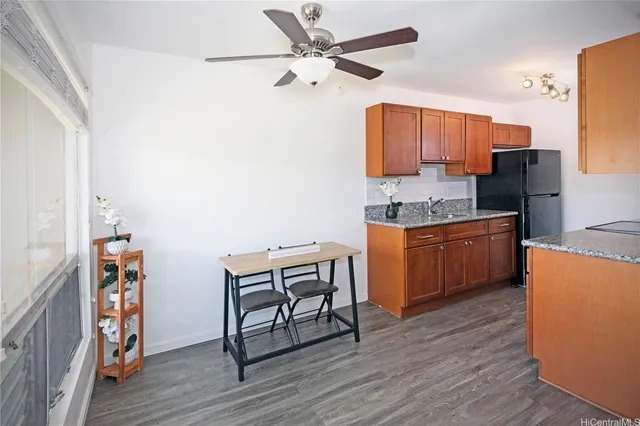 a kitchen with stainless steel appliances granite countertop a table chairs a stove and a refrigerator