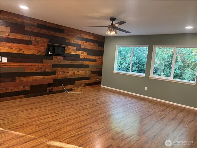 a view of room with wooden floor and windows