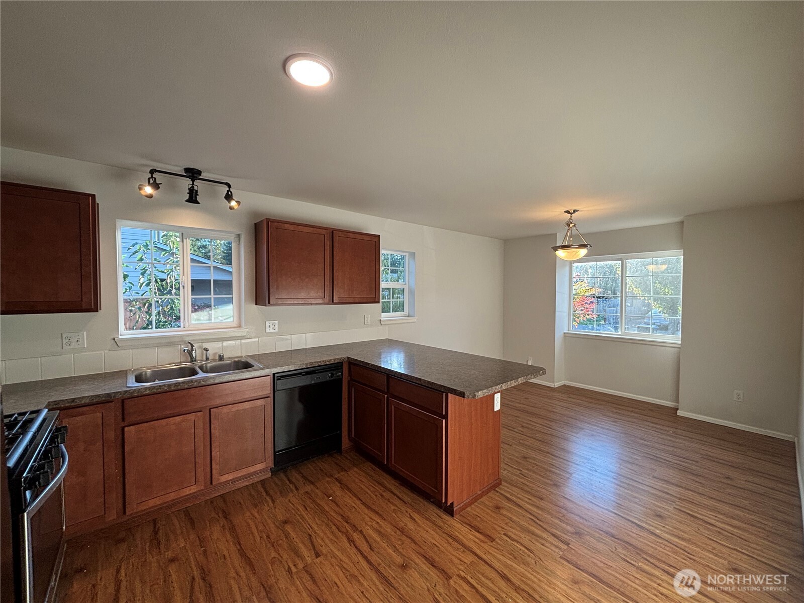 7796 Kildare Loop Northwest Silverdale, WA 98383 - Photo 4 of 14 a kitchen with stainless steel appliances granite countertop wooden floors and sink