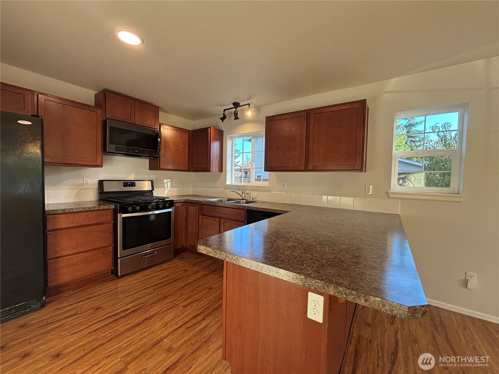 7796 Kildare Loop Northwest Silverdale, WA 98383 - Photo 6 of 14 a kitchen with granite countertop a refrigerator and a stove top oven
