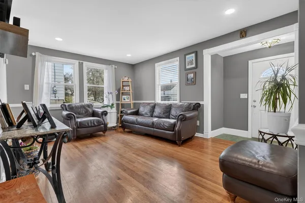 a living room with furniture wooden floor and a large window