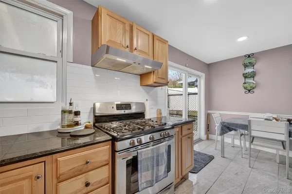 a kitchen with stainless steel appliances granite countertop a stove a sink and a refrigerator