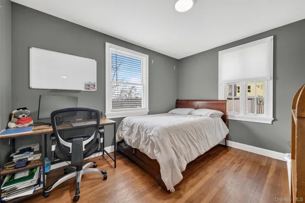 a bedroom with a bed and a computer on the desk