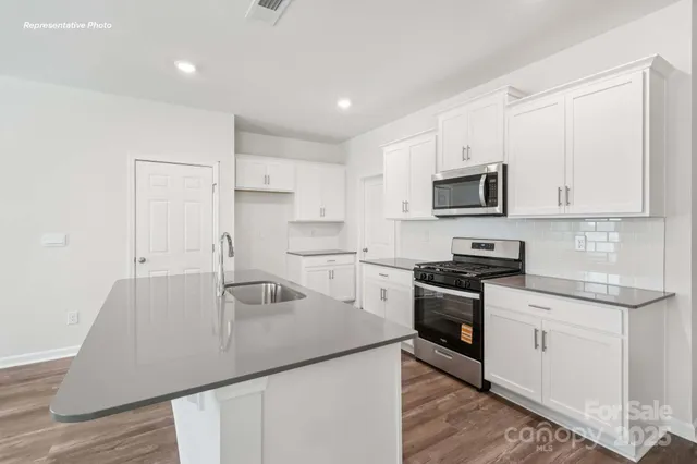 a kitchen that has a sink and a stove top oven