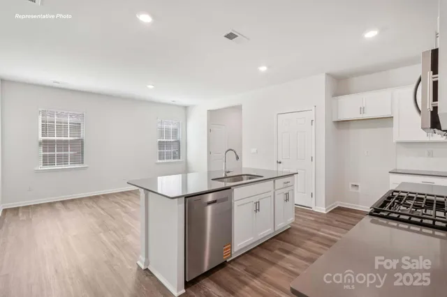 a kitchen with stainless steel appliances granite countertop a stove a sink and a refrigerator