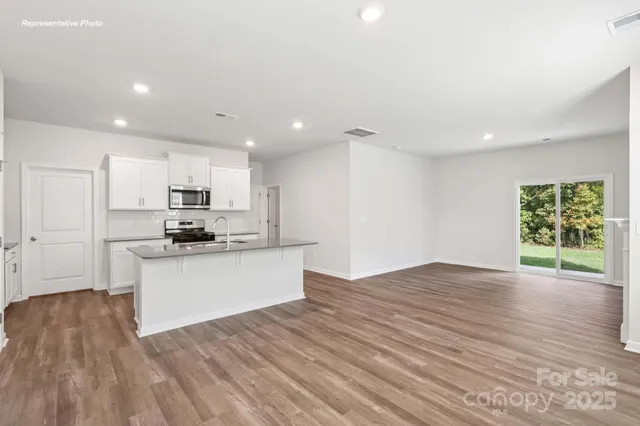 a view of kitchen with wooden floor and electronic appliances