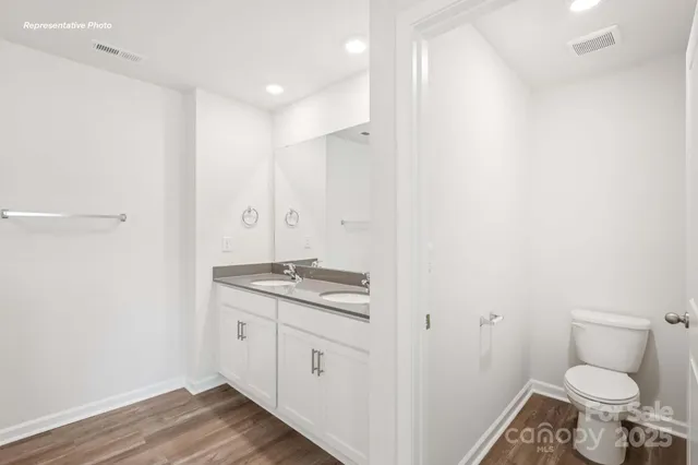 a bathroom with a granite countertop toilet and a sink