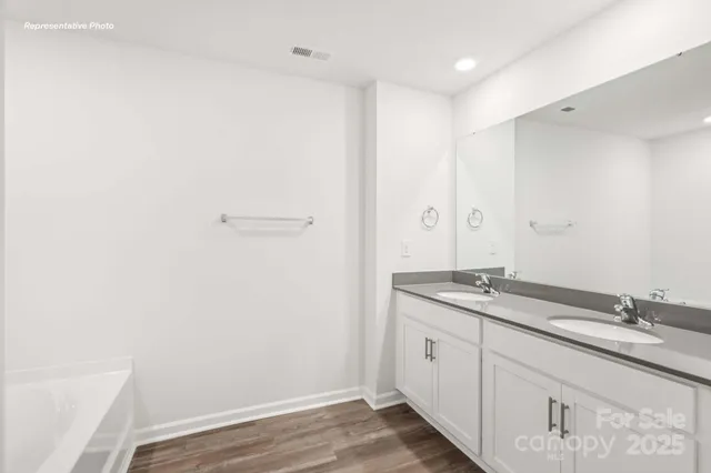a spacious bathroom with a granite countertop sink and a mirror