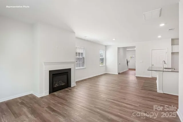 a view of empty room with wooden floor and fireplace