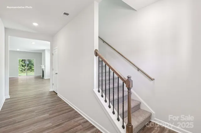 a view of a hallway with wooden floor and staircase