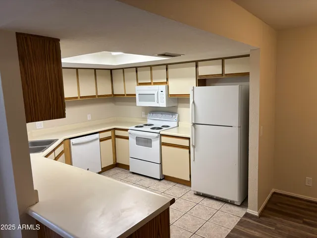 a white kitchen with a sink and refrigerator