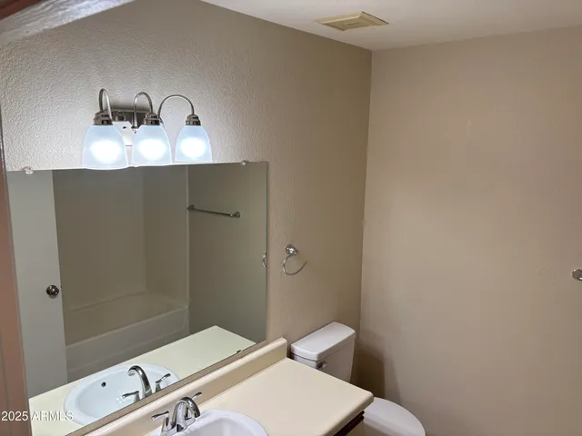 a bathroom with a sink a toilet and mirror