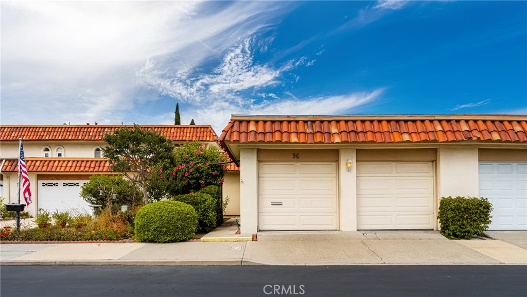 a front view of a house with plants
