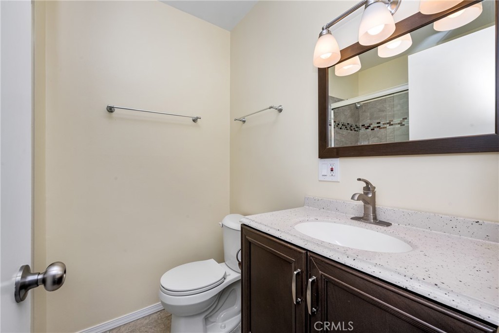 96 Seton Road Irvine, CA 92612 - Photo 33 of 35 a bathroom with a granite countertop sink a toilet and a mirror