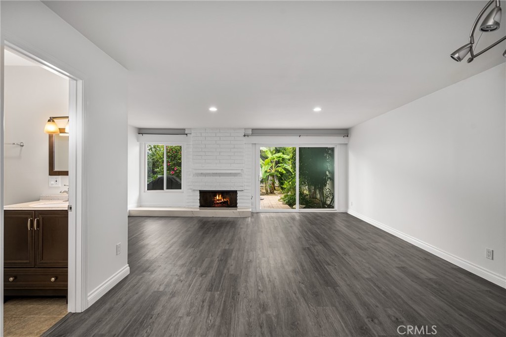 96 Seton Road Irvine, CA 92612 - Photo 8 of 35 an empty room with wooden floor fireplace and windows