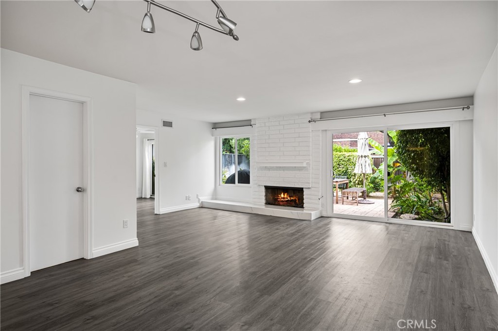 96 Seton Road Irvine, CA 92612 - Photo 9 of 35 an empty room with wooden floor fireplace and windows