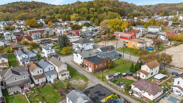 an aerial view of a city with lots of residential buildings ocean and mountain view in back