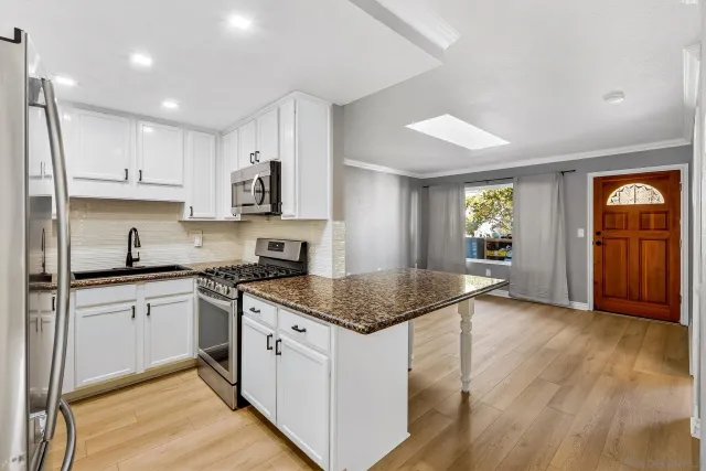 a kitchen with stainless steel appliances granite countertop a sink stove and refrigerator
